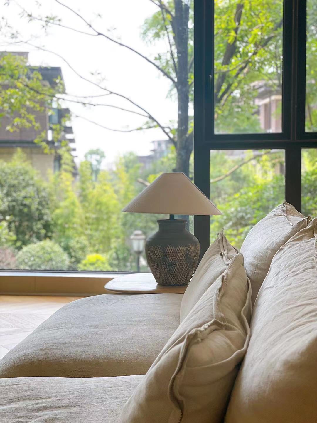 rustic-carved-ceramic-table-lamp-with-white-linen-drum-shade-and-handcrafted-earth-toned-finish