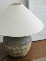rustic-carved-ceramic-table-lamp-with-white-linen-drum-shade-and-handcrafted-earth-toned-finish