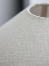 rustic-carved-ceramic-table-lamp-with-white-linen-drum-shade-and-handcrafted-earth-toned-finish