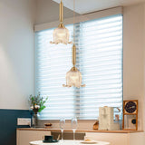 modern-brass-floral-pendant-light-with-clear-crystal-glass-shade-for-dining-areas