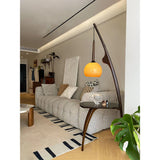 Modern Curved Mantis Wood Floor Lamp with Amber Glass Orb Shade for Living Room and Bedroom