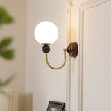 mid-century-walnut-wood-wall-sconce-lighting-with-white-glass-shade-and-pull-cord-switch