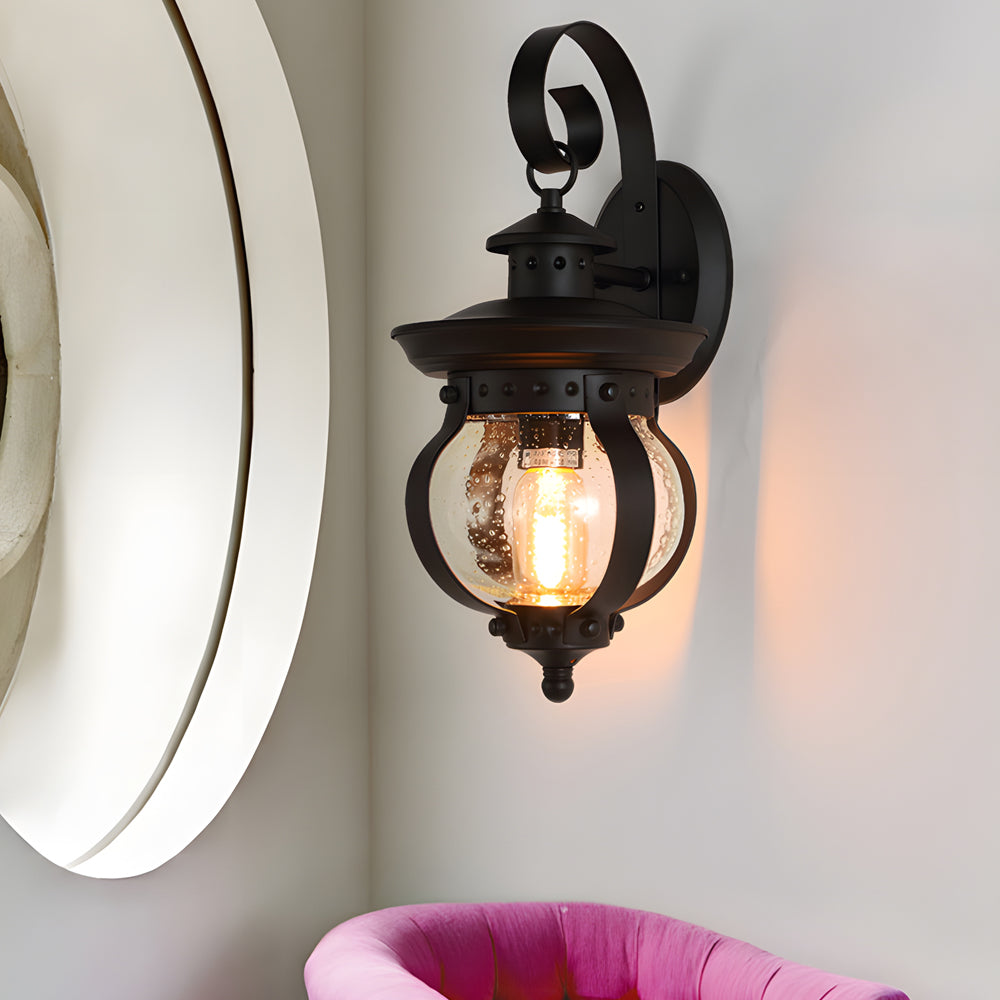 Black Outdoor Wall Lantern with Seeded Glass Globe and Curved Arm Design