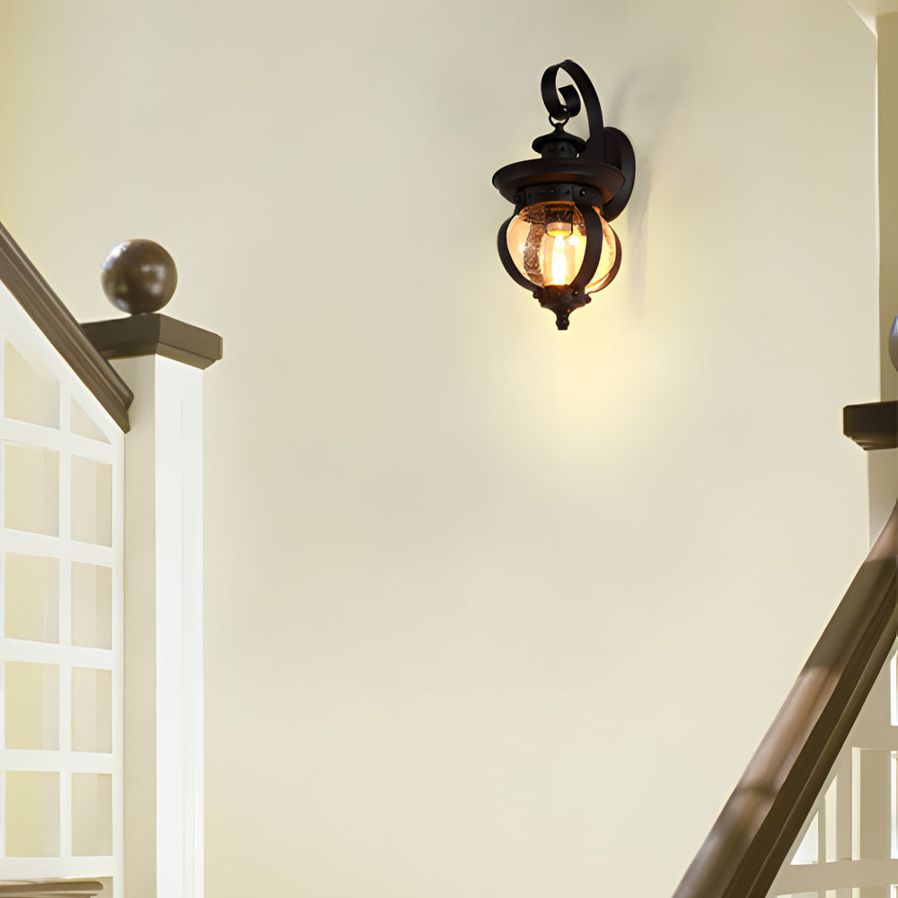 Black Outdoor Wall Lantern with Seeded Glass Globe and Curved Arm Design