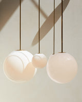 Modern Brass Rod Pendant Light with Spherical Mouth Blown Opal Glass Globe