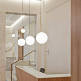 modern-brass-and-opal-glass-globe-pendant-light-minimalist-baton-design-hanging-lamp