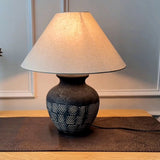 rustic-carved-ceramic-table-lamp-with-white-linen-drum-shade-and-handcrafted-earth-toned-finish