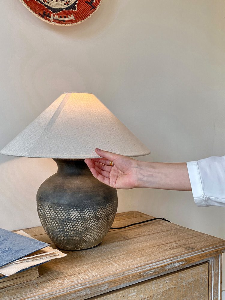 rustic-carved-ceramic-table-lamp-with-white-linen-drum-shade-and-handcrafted-earth-toned-finish
