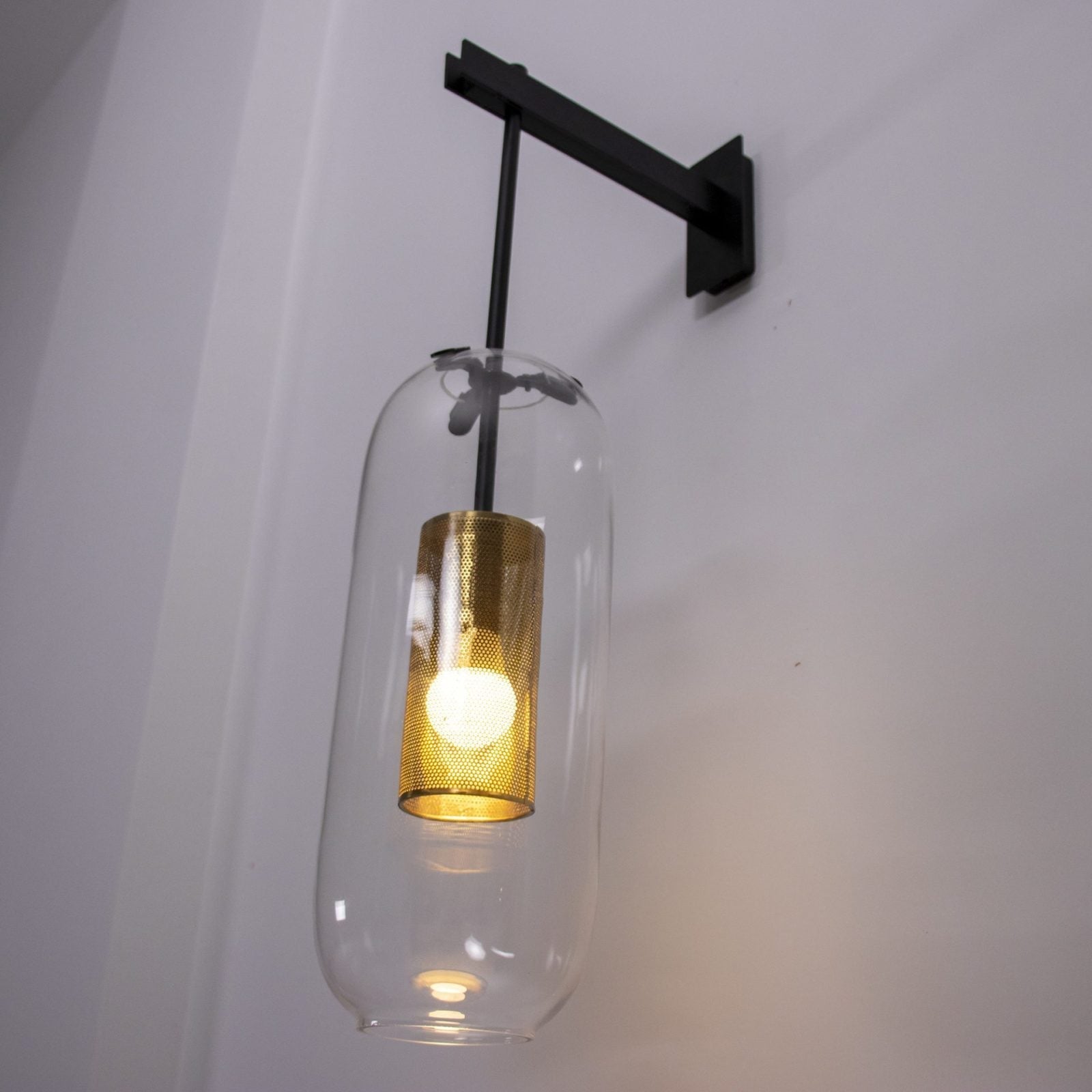 modern-vadim-glass-wall-sconce-with-perforated-metal-cage-and-brass-finish-for-luxury-interiors