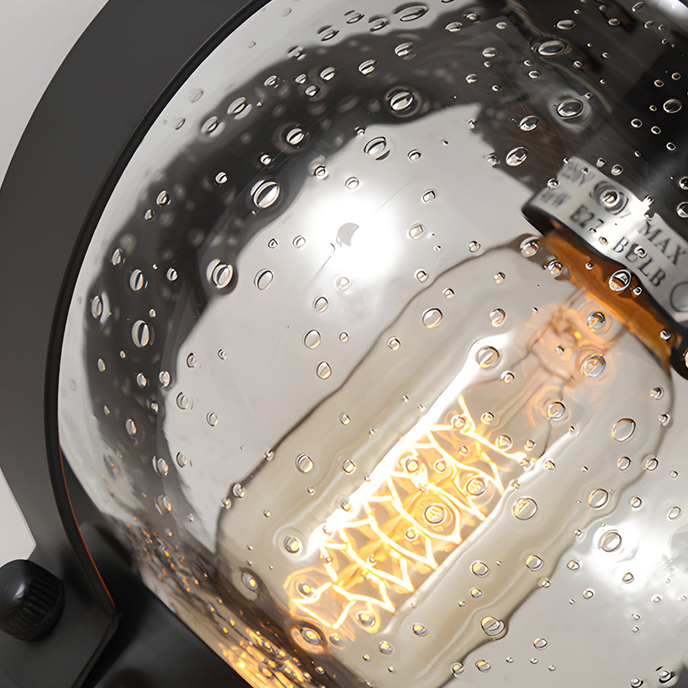 Black Outdoor Wall Lantern with Seeded Glass Globe and Curved Arm Design