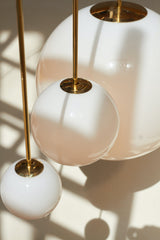 Modern Brass Rod Pendant Light with Spherical Mouth Blown Opal Glass Globe