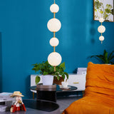 Modern Vertical Glass Globe Pendant Light in Black and Brass Finishes