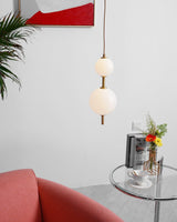 Modern Vertical Glass Globe Pendant Light in Black and Brass Finishes