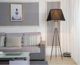 modern-solitaire-tripod-floor-lamp-with-black-polygonal-cloth-shade-and-brass-accents