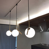 modern-brass-and-opal-glass-globe-pendant-light-minimalist-baton-design-hanging-lamp