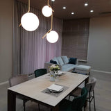 modern-brass-and-opal-glass-globe-pendant-light-minimalist-baton-design-hanging-lamp